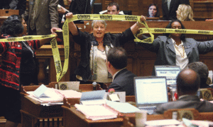At age 70, Orrock has not stopped standing up for what she believes is right. Here she and colleagues ring the floor of the Georgia Senate Chamber in 2012 holding yellow caution tape to protest a bill they believe to be harmful to women. Photo provided by AP Images/Jason Getz, AJC.
