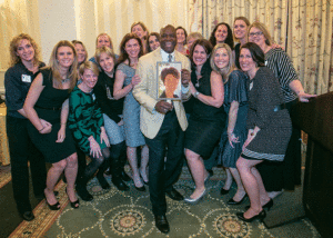 The 1993 UMW field hockey team surrounds Darrell Green, special assistant to student athletes, who holds a photo of a team member who was unable to attend the February awards banquet.