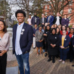 Farmer's legacy continues, as today's campus leaders pose with current and former staff members by the bust of Dr. Farmer on Campus Walk.